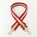 Close-up of adjustable nylon bag strap with red, white, and gold striped pattern - Burgundy