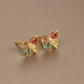 Elegant gold butterfly stud earrings with colorful zircon stones on beige background - Butterfly Colorful Zirconia / Gold