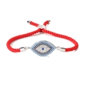 Detailed macro view of Evil Eye charm on red woven rope bracelet with zircon stones - Red Rope-Long Silver Eye