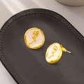 Elegant gold oval earrings with a white pearlescent base and 3D rose flower carving - Small Rose Embossed / Gold
