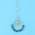 Detail of suncatcher with golden sun face, crescent moon, and blue natural stones - Blue Sodalite