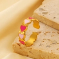 Dettaglio anello a cuore dorato con smalto rosa su base in pietra naturale - Cuore Rosa Acciaio Inossidabile