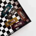 Five assorted rectangle resin hair clips in dark jelly colors on a checkerboard tray - Hollow Rectangle 5PCS