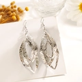 Vue macro de boucles d'oreilles feuilles multicouches argentées avec texture brossée fine - Feuilles Multi-couches Brossées
