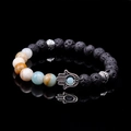 Macro detail of Hamsa Hand charm on lava rock and colorful natural stone beaded bracelet - Amazonite