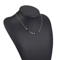 Bohemian gold paperclip chain necklace with black and white beads on a black bust display - Neutral Black White Grey Beads