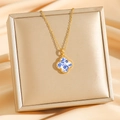 Golden clover necklace with blue floral porcelain pattern on elegant silk background - Gold