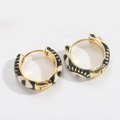 Detailed view of gold hoop earrings with black and white enamel eye patterns - Black