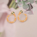Macro detail of gold snake earring with orange enamel, green gems and white zircons - Orange