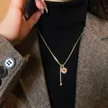 Collana a strati dorata con perla barocca e ciondolo a stella su maglione nero - Collana con ciondolo a piccola sfera dorata girasole in occhio di tigre - circonferenza circa 50 cm