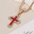 Macro detail of gold cross pendant with red square gemstone and white zircon accents - Cross / Gold Chain with Red Pendant