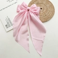 Detailed macro view of soft pink satin bow hair clip with long elegant ribbons - Light Pink