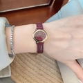 Women's quartz watch featuring a red leather strap and golden dial on wrist - Flat Oval Dial