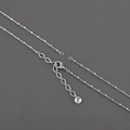 Gros plan d'un collier en plaqué rhodium avec fermoir mousqueton et perle à facettes - Chaîne Minimaliste Argentée