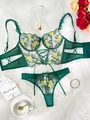Flat lay of lace lingerie set with floral embroidery and bow details on white fabric - Yellow Plus Green