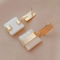 Detailed close-up of golden metal earrings with white square shell pendants on beige fabric - Gold Geometric Earrings (925 Silver Needle)