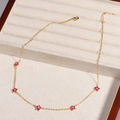 Macro detail of gold flower necklace with pink gemstones in a velvet jewelry box - Red Flower - Gold