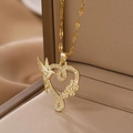 Collar de colibrí dorado con corazón y símbolo de infinito en un joyero beige - Dorado