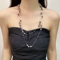 Collana a doppio strato con perle argentate e nere su una modella elegante su bianco - Collana di Perline a Doppio Strato Argento e Nero