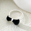 Detailed view of silver bow ring with black enamel finish on a soft textured background - Black Enamel Bow Ring (N-430) / Black