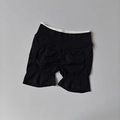 Detail of high-waisted seamless yoga shorts showing scrunch butt texture and contrast color - Black