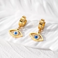 Detailansicht der vergoldeten Creolen mit Evil-Eye-Motiv auf strukturiertem Hintergrund - Blaues Hohles Auge