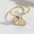 Dettaglio macro dell'anello regolabile dorato con occhio greco blu e cristallo a goccia - Stile Occhio del Diavolo Blu Reale