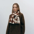 Knit scarf with brown and beige diamond checkered patterns worn by a model - White & Brown