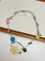 Detail of silver chain necklace with colorful beads and beige flower pendant on fabric - Flower Pendant Necklace (XL0341)