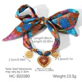 Vue détaillée du collier foulard en soie fleurie avec pendentifs soleil, cœur et papillon - Bracelet Foulard en Soie (HC-B20380)