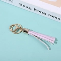 Pink and white PU tassel keychain with golden metal ring on a minimalist background - Pink and White