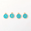 Detailed view of four golden alloy round letter pendants with blue enamel for DIY jewelry - Letter A / Sky Blue