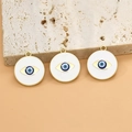 Detailansicht von drei goldenen Anhängern mit blau-weißem Emaille-Auge auf Naturstein - 20.9mm / Stil 16# Böser Blick Runde Medaille / 1 Stück