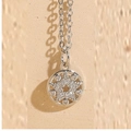 Macro shot of silver star pendant necklace with micro-paved zircons and polished finish - Round Star White Gold Color