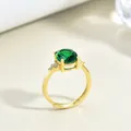 Vintage gold ring featuring a large oval emerald gemstone with zircon accents in four-claw setting - Ring / Gold