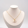 Elegante collana di perle d'acqua dolce dorate con ciondolo a conchiglia su manichino - Collana Oro