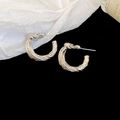 Detail view of silver twisted C-shaped earrings with vintage metallic texture and finish - Knotted Twisted C-shape Earring / Silver