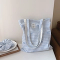 Dettaglio della borsa tote in cotone a quadretti blu con ricamo a fiocco e scrunchie - Borsa a Tracolla a Doppia Tracolla