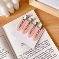 Set aus vier pastellrosa haarspangen aus harz auf einer weißen karte mit metallbasis - Rosa