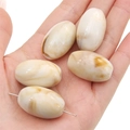 Handheld view of cream and brown marble pattern acrylic oval beads for DIY jewelry - Light Coffee Oval Bead (5pcs/pack) / 18x29mm