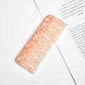 Detail of peach acetate wide-tooth hair comb with marble pattern on vintage book - Peach Spotted