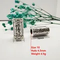 Detailed macro view of antique silver barrel beads with Tibetan mantra engravings - Style 10 (Mantra Carving)