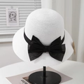 Detail view of white breathable straw hat with black satin bow on a metal stand - Adjustable (57.5cm) / White