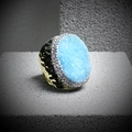 Detail of light blue crystal cluster ring with gold hammered band on grey block - Adjustable Open / Blue