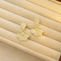 Elegant gold flower tassel earrings with cream enamel finish on jewelry display - Gold Enamel Flower Fan Shape