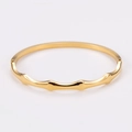 Vista detallada de un brazalete de acero inoxidable dorado con diseño de onda pulido - Dorado