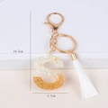 Detail showing letter S keychain with gold foil, white shell flakes and white tassel - S