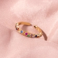 Detail view of gold open ring with colorful zircon stones on soft pink fabric - Gold Rainbow Zircon