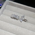 Makro-Detail von silbernen Ohrmanschetten mit Baguette- und Birnen-Zirkonia-Kristallen - 7# Baguette-Pavé und Dreifach-Zirkonia-Blumencluster-Set (2-teilig)