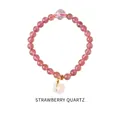 Close-up of strawberry quartz beaded bracelet with a white cat charm and golden metal parts - Strawberry Quartz Cat Head Pendant Style (WB335)